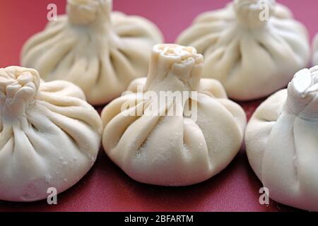 Khinkali fatti in casa su un tavolo da cucina in plastica. Khinkali georgiani crudi con carne di agnello. Foto Stock