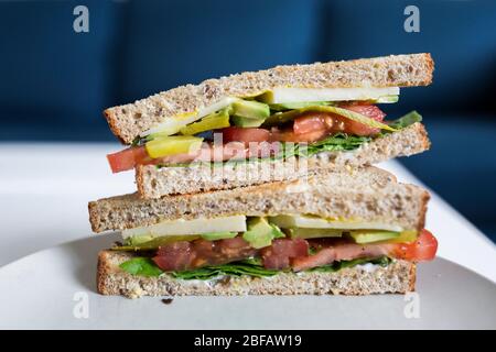 Un sano panino vegetariano su pane integrale si siede su un piatto pronto per il pranzo. Foto Stock