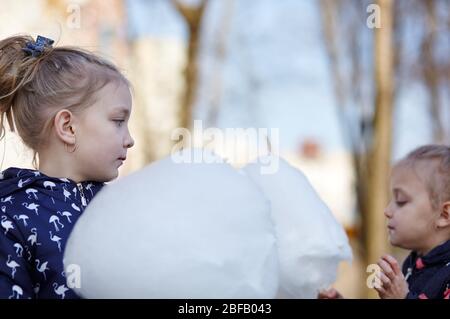 Carino ragazze mangiare caramelle di cotone. Infanzia felice e emozioni dei bambini Foto Stock