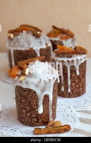 Deliziosa torta di Pasqua fatta in casa sul tovagliolo bianco con altri sullo sfondo decorato da banane secche, albicocche d'arancia, mandorle e piccolo elegan Foto Stock