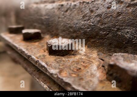 Una fila di bulloni arrugginiti su un vecchio macchinario Foto Stock