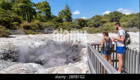 Visitatori presso una piscina di fango presso il Wai-o-Tapu Thermal Wonderland, vicino Rotorua, Nuova Zelanda Foto Stock