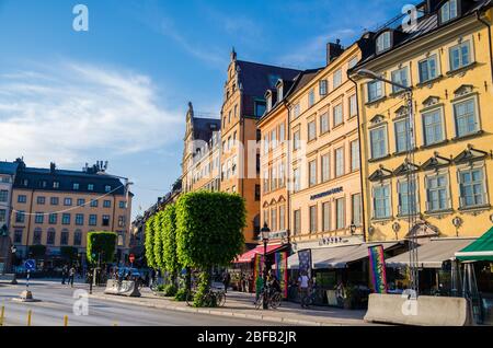 Svezia, Stoccolma, 29 maggio 2018: Tradizionali edifici tipici con pareti colorate, alberi verdi sulla piazza del porto di Kornhamnstorg nella città storica Foto Stock