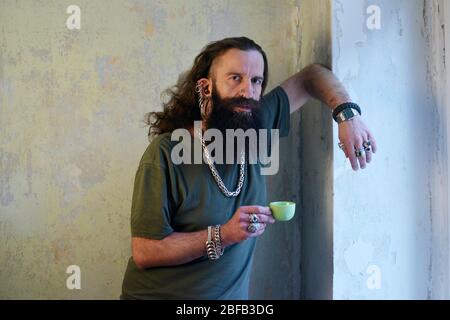 un lungo uomo con i capelli e i bearded in piedi facendo una rottura Foto Stock