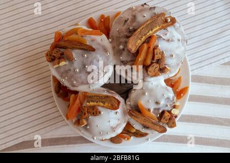 Vista dall'alto del tradizionale kulich pasquale ortodosso. Quattro deliziose torte alla moda insieme al piatto decorato da banane secche, albicocche d'arancia, mandorla Foto Stock