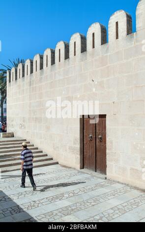 Uomo locale che cammina davanti alla facciata della Grande Moschea nella Medina, Sousse, Tunisia Foto Stock