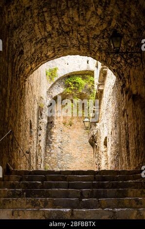 Muri in pietra, scale e lampada al coperto dell'antica torre del Castello Doria a Portovenere, la Spezia, Liguria, Italia Foto Stock