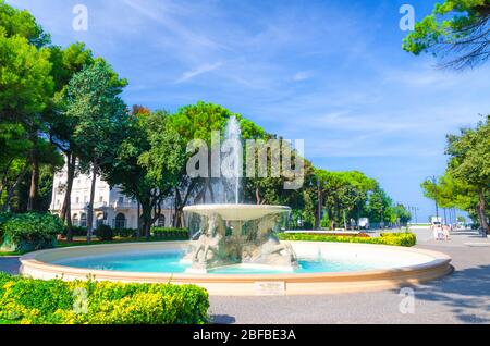 Quattro cavalli fontana a quattro cavalli con acqua turchese nel Parco Federico Fellini con alberi verdi nel centro turistico di Rimini con il blu di sk Foto Stock