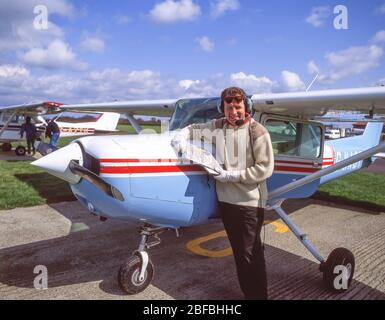 Pilota maschile accanto a un aereo Cessna 172 Skyhawk, Blackbushe Airport, London Road, Blackwater, Hampshire, Inghilterra, Regno Unito Foto Stock