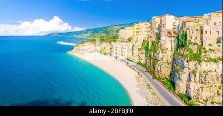 Vista panoramica aerea della città di Tropea e della costa della spiaggia del Mar Tirreno con acque azzurre turchesi, case colorate edifici sulla cima di alto grande ro Foto Stock