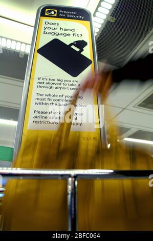 Una donna si controlla che la borsetta si inserisce i criteri rigorosi presso l'aeroporto di Heathrow. Foto Stock