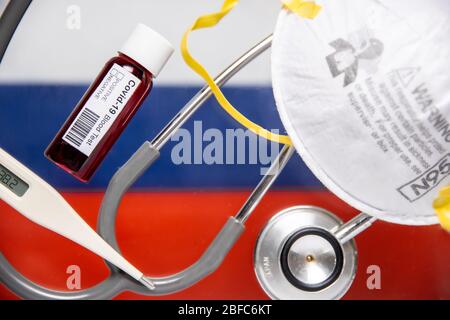 Concetto di sfondo pandemico di Coronavirus o Covid-19 con bandiera russa e test del sangue medico, stetoscopio, maschera chirurgica N95 Foto Stock