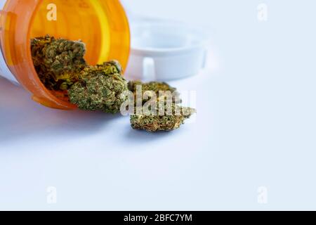 Marijuana medica C. marijuana medica che versa fuori da una bottiglia di prescrizione contro il bianco. Foto Stock