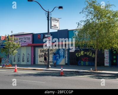 11 aprile 2020, Las Vegas, Nevada, USA, coppia utilizzando i telefoni cellulari per scattare foto di imprese a bordo nel centro del quartiere delle arti a causa di Covid-19 sh Foto Stock