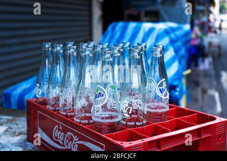 Scatola con bottiglie di vetro vuote di Coca Cola, e altre bevande. Bottiglie in vetro per il riciclaggio. Foto Stock