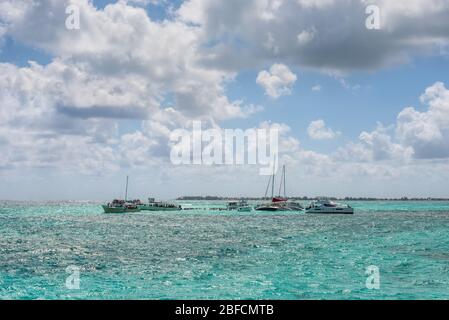 George Town, Grand Cayman Islands, Regno Unito - 23 aprile 2019: Le persone godono di giocare con le razze al sandbar di Stingray City sulla Gran CA Foto Stock