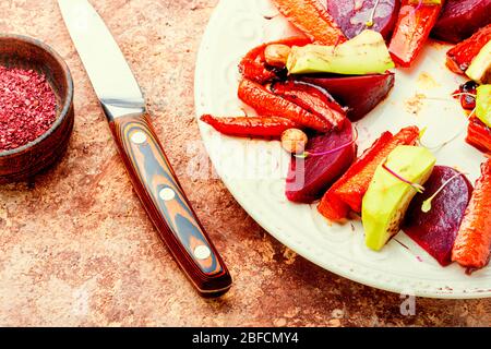 Insalata con carote caramellate, avocado, barbabietole e noci. Foto Stock