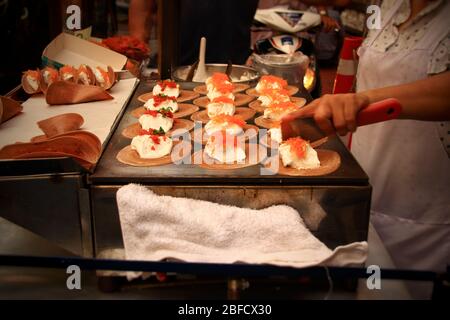 Vendita di cibo di strada che cucina e vende spuntini tradizionali chiamati khanom bueang o crepe croccante thailandese, mostrando la cultura locale e la cucina della Thailandia Foto Stock