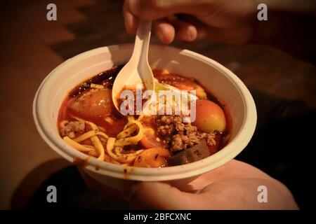 Zuppa di Laksa fatta di tagliatelle di grano e latte di cocco al curry piccante, un piatto popolare in cucina Peranakan o Malese Foto Stock