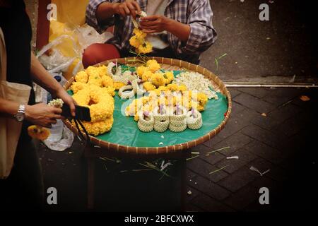 Venditore tailandese di strada che vende Phuang malai o malai, che è un ghirlanda di fiori utilizzato per offerte buddhiste e fascino per buona fortuna nella cultura tailandese A. Foto Stock