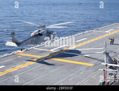 OCEANO PACIFICO (8 aprile 2020) – un falco marino MH-60S, assegnato alle "Wildcards" di elicottero Sea Combat Squadron (HSC) 23, atterra sul ponte di volo della nave d'assalto anfibia USS Makin Island’s (LHD 8). Makin Island sta conducendo operazioni di routine nel Pacifico orientale. (STATI UNITI Foto marina di Mass Communication Specialist 1a Classe Harry Andrew D. Gordon) Foto Stock