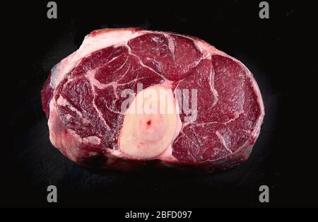 Gambo di vitello ossobuco su sfondo nero. Vista dall'alto Foto Stock