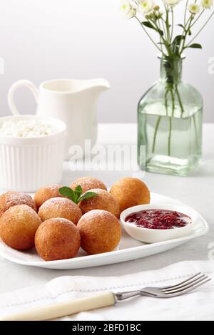 La colazione era ottima. Palline di ciambelle di formaggio cottage su uno sfondo chiaro. Foto Stock