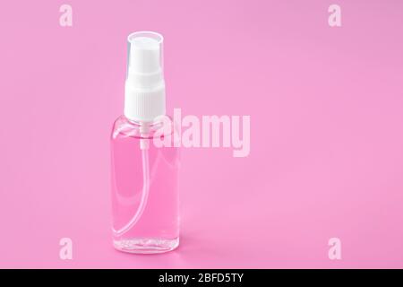 Disinfettante spray per le mani in flacone su fondo rosa. Mockup con posto vuoto. Concetto di disinfezione, protezione da coronavirus covid-19. Antibatterici Foto Stock