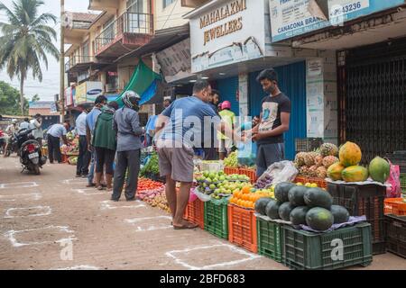 La gente che fa il loro shopping mattutino della verdura al posto designato del mercato durante il blocco del virus Covid-19 a Goa, India. Foto Stock