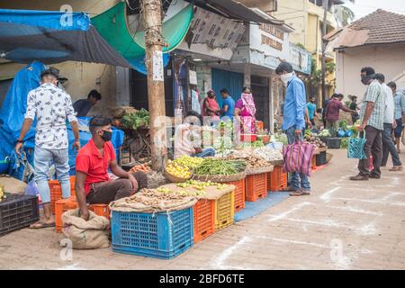 La gente che fa il loro shopping mattutino della verdura al posto designato del mercato durante il blocco del virus Covid-19 a Goa, India. Foto Stock