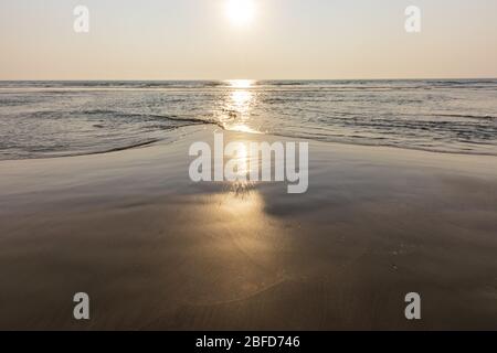 Tramonto sulla spiaggia di Mandrem a Goa, India. Mare e fondo esposto alla sera. Foto Stock