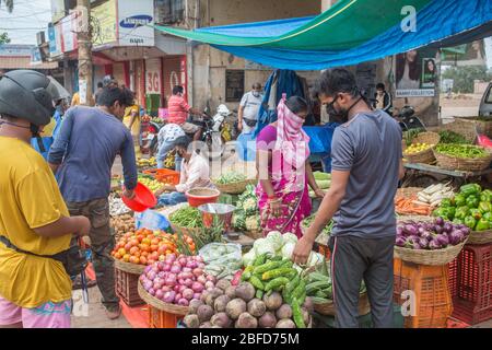 La gente che fa il loro shopping mattutino della verdura al posto designato del mercato durante il blocco del virus Covid-19 a Goa, India. Foto Stock