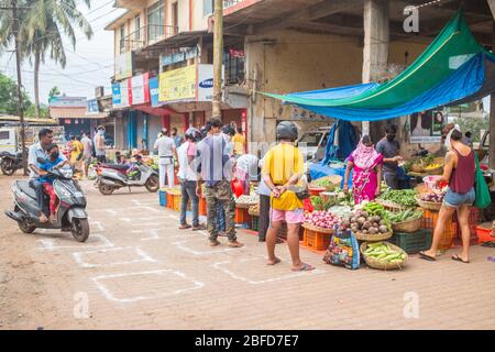 La gente che fa il loro shopping mattutino della verdura al posto designato del mercato durante il blocco del virus Covid-19 a Goa, India. Foto Stock