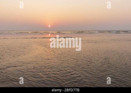 Tramonto sulla spiaggia di Mandrem a Goa, India. Mare e fondo esposto alla sera. Foto Stock