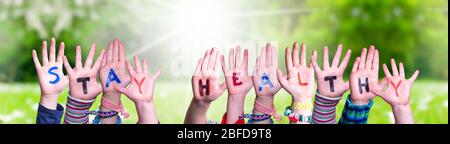 Mani dei bambini tenuta Parola rimanere sano, prato erba Foto Stock