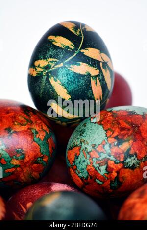 Le uova ortodosse di Pasqua il giorno di Pasqua si sono allineate in un mucchio su sfondo bianco Foto Stock