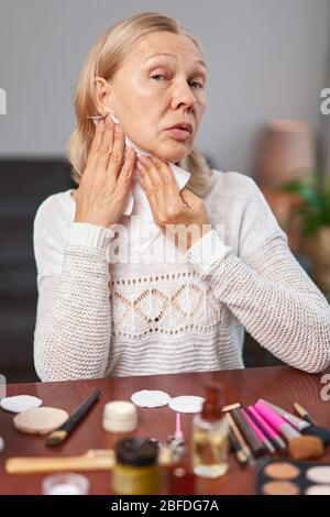 Donna anziana che mette sul make-up Foto Stock