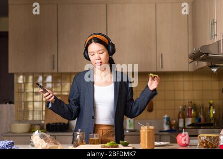 Donna allegra che si fida in cucina dopo aver trascorso troppo tempo all'interno Foto Stock