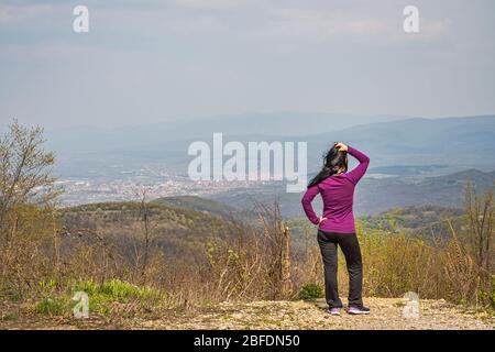 La ragazza si erge su una scogliera e guarda verso Stara Planina Foto Stock