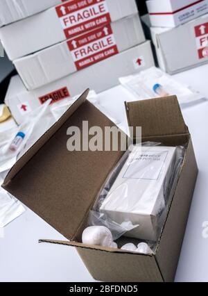 Scatole con kit per PCR Covid-19 in magazzino ospedaliero, immagine concettuale Foto Stock