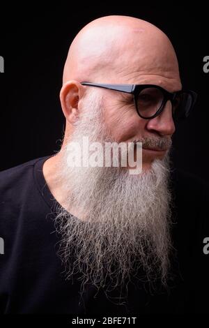 Uomo maturo baldo bearded contro sfondo nero Foto Stock