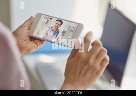 Medico online. Il medico consulta via video chat femminile paziente utilizzando un portatile mobile seduto a casa. Foto Stock