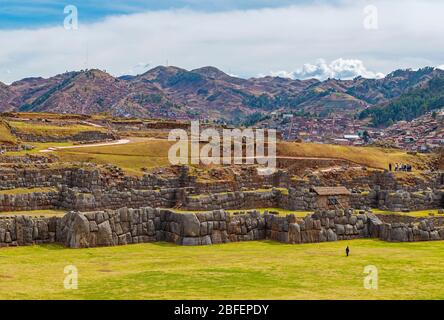 La rovina inca di Sacsayhuaman con un turista irriconoscibile e gigantesche mura inca, Cusco, Perù. Foto Stock