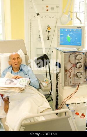 Un paziente rene in visita regolare nel reparto di dialisi renale di un ospedale londinese dove è collegato ad una macchina per emodialisi che essentiall Foto Stock