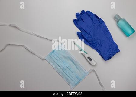 Guanti per uso medico, maschera facciale, termometro a febbre, gel igienizzante per alcol. Protezione personale contro il nuovo coronavirus, Covid-19 pandemic Foto Stock