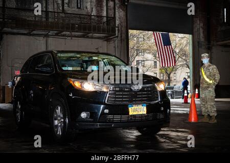 Bronx, Stati Uniti d'America . 18 Aprile 2020. Un soldato dell'esercito degli Stati Uniti istruisce un driver del taxi all'Armeria di Kingsbridge nel Bronx il 18 aprile 2020. L'armoria è utilizzata come centro di distribuzione alimentare temporaneo durante la crisi COVID-19 e i soldati dell'esercito statunitense caricano i pasti nelle cabine di autisti autorizzati TLC che li consegnano ai newyorkesi in necessità durante la pandemia COVID-19. (Foto di Gabriele Holtermann-Gorden/Sipa USA) Credit: Sipa USA/Alamy Live News Foto Stock