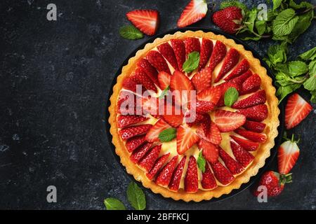 Chiudere un'op di torta di fragole e flan intorno alle bacche e alla menta Foto Stock