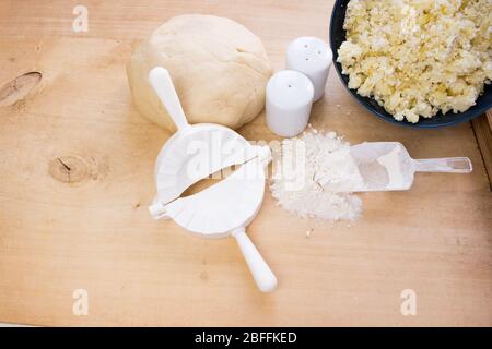 Cucina nazionale russa. Pierogi o pirohy, vareniki, servito con formaggio casolare e patate a bordo. Gnocchi crudi di pasta in fiocco fatto a mano Foto Stock