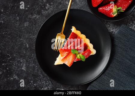 Primo piano di deliziosa pace di torta di fragole su nero sfondo Foto Stock