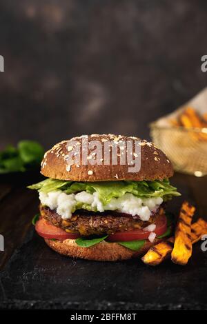 Delizioso hamburger di lenticchie vegane fatto in casa su uno sfondo rustico scuro Foto Stock